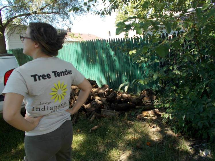 Permaculture designer Katherine supervises unloading of logs for hugelkultur.